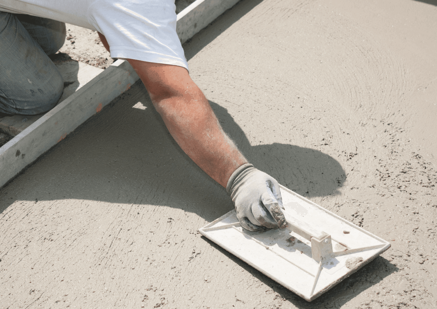 Maçon coulant une dalle béton sur un chantier de maçonnerie générale